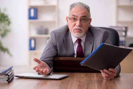 Old male employee working in the officeの写真素材
