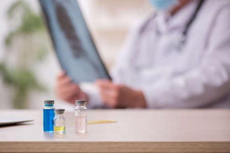 Old male doctor radiologist working in the clinic during pandemiの写真素材