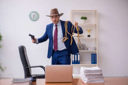 Young cowboy businessman working at workplaceの写真素材
