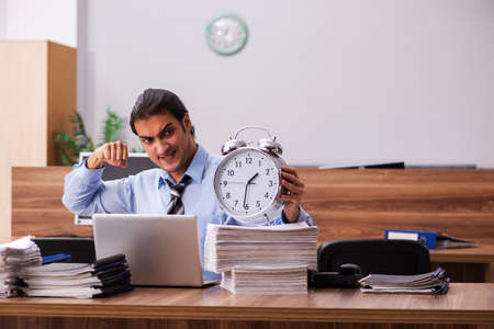 Young male employee in time management conceptの写真素材