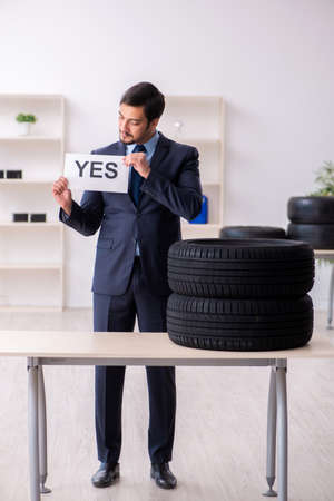 Young man selling tires in the officeの写真素材
