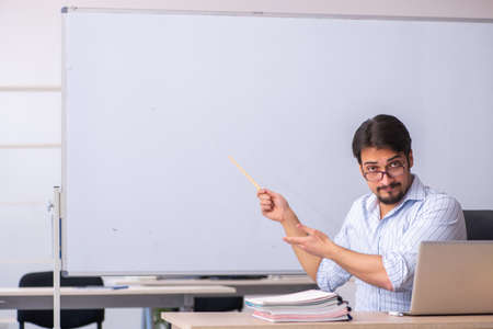 Young male teacher in front of whiteboardの写真素材