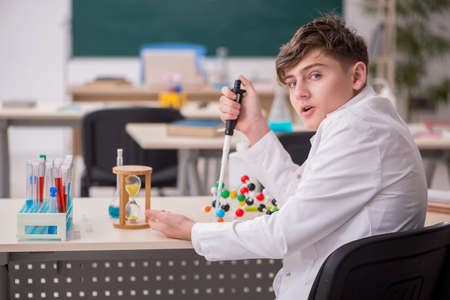 Schoolboy studying chemistry in the classroomの写真素材