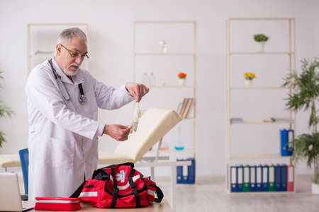 Old male doctor in first aid conceptの写真素材