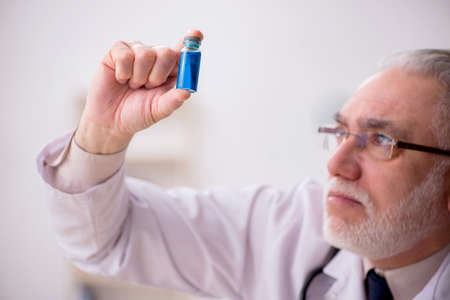 Old male doctor in vaccination conceptの写真素材
