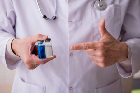 Old male doctor in vaccination conceptの写真素材