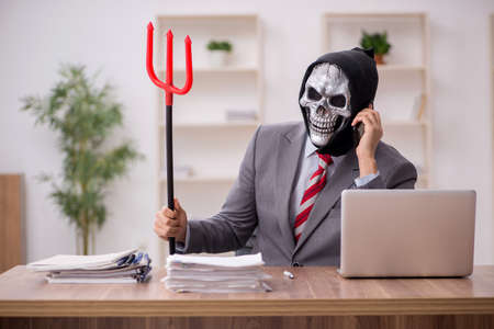 Devil businessman employee sitting at workplace