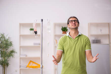 Young sick male teacher student in blood transfusion conceptの写真素材
