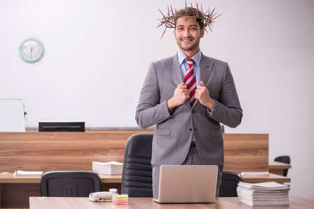 Young male employee wearing prickly wreath on headの写真素材