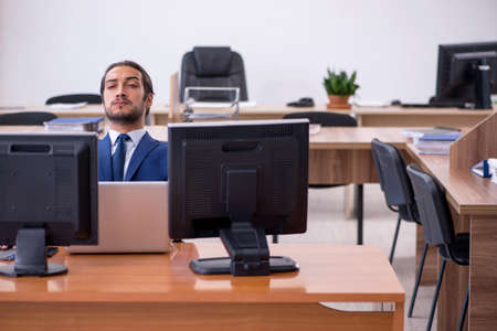 Young male employee in multitasking conceptの写真素材