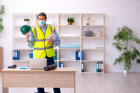 Young male architect working in the office during pandemicの写真素材
