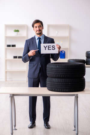 Young man selling tires in the officeの写真素材