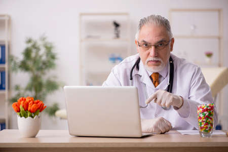 Old male doctor pharmacist working in the clinicの写真素材