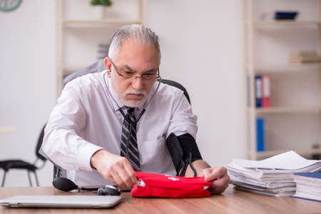 Aged male employee suffering at workplaceの写真素材