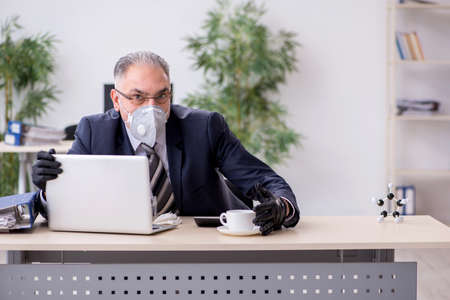 Old male boss employee working during pandemicの写真素材