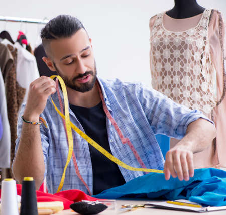 Male tailor working in the workshop on new designs