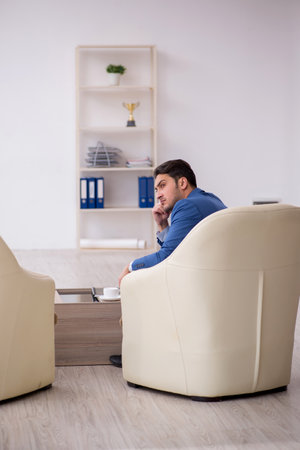 Young male employee waiting for business meetingの写真素材
