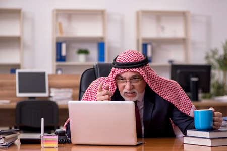 Aged arab businessman employee drinking coffee during breakの写真素材