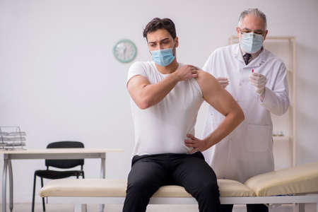 Young male patient visiting old male doctor in vaccination conceの写真素材