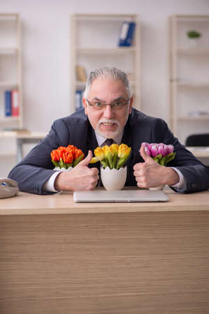 Old businessman florist sitting in the officeの写真素材