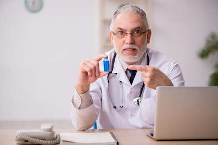 Old male doctor in vaccination conceptの写真素材