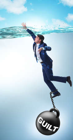 Businessman drowning under the burden of sin and guiltの写真素材