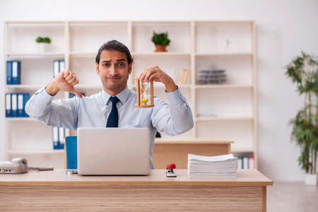 Young male employee in time management concept
