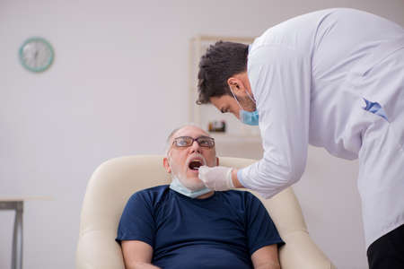 Old male patient visiting young male doctor otorhinolaryngologis