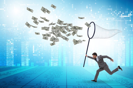Young businessman catching dollars with landing netの写真素材