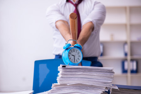 Young businessman employee in time management conceptの写真素材