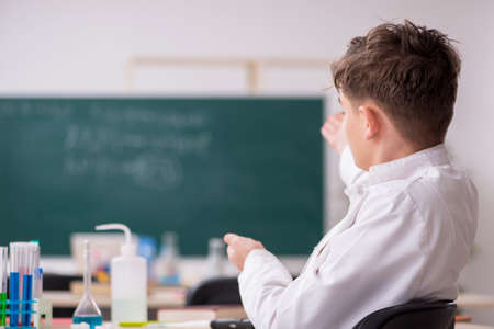 Schoolboy studying chemistry in the classroomの写真素材