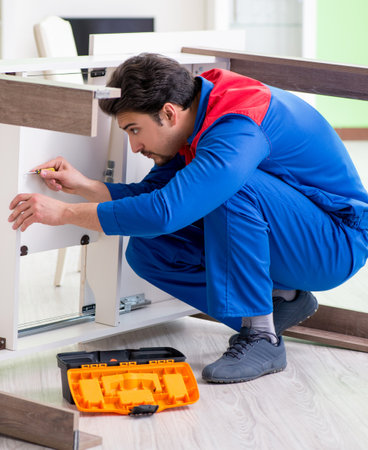Repair contractor repairing broken furniture at homeの写真素材