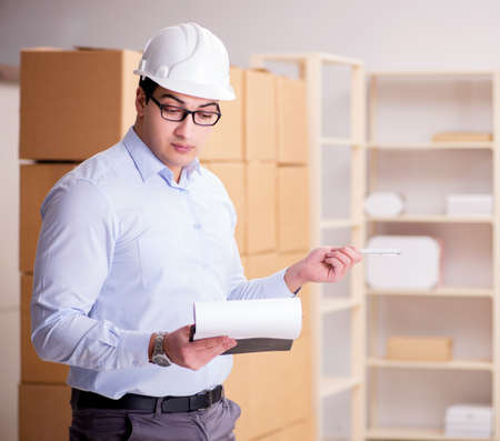 Young worker in the postal office dealing with parcels