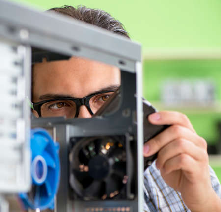 Computer engineer repairing broken desktopの写真素材