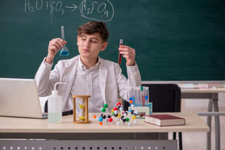 Schoolboy studying chemistry in the classroom