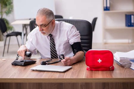 Aged male employee suffering at workplaceの写真素材