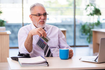 Aged businessman employee unhappy with excessive workの写真素材