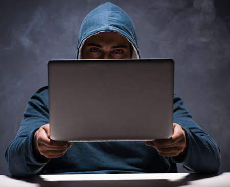 Computer hacker working in dark room