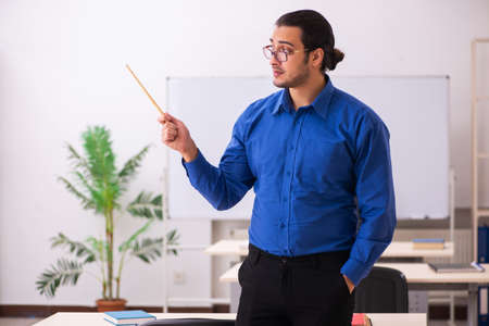 Young male teacher in front of whiteboardの写真素材