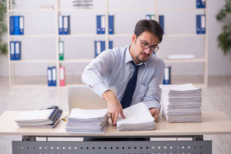 Young businessman employee unhappy with excessive workの写真素材