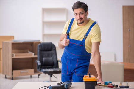 Young male carpenter working in the office
