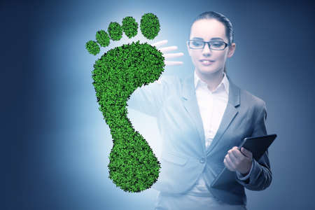 Ecology concept with green footprint and businesswomanの写真素材
