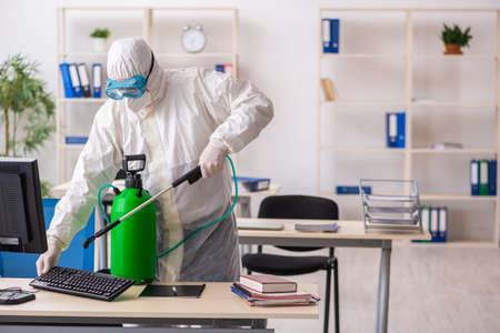 Old male contractor in office disinfection conceptの写真素材