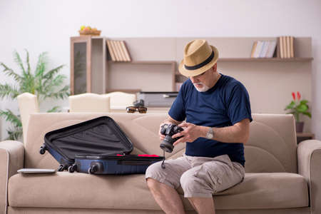 Old man preparing for trip at home