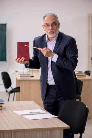 Old male teacher in front of blackboardの写真素材
