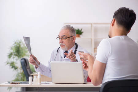 Young male patient visiting old male doctor radiologistの写真素材