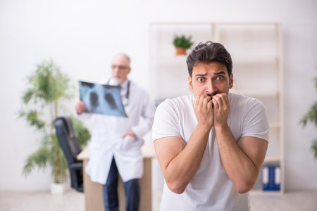 Young male patient visiting old male doctor radiologistの写真素材