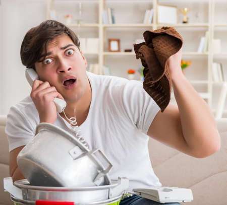 Man at home dealing with neighbor flood leakの写真素材
