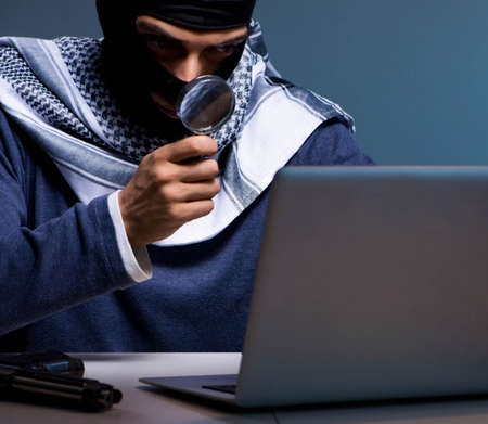 Hacker wearing balaclava mask hacking computer