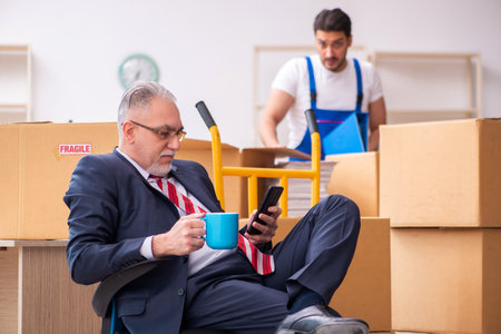 Old businessman and young contractor in relocation concept